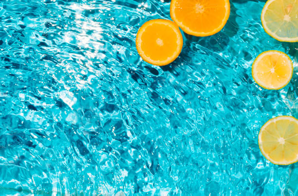 escena veraniega con fruta de naranja y limón en agua. sunligt y sombras. fondo de naturaleza mínima. - lemon isolated clean water fotografías e imágenes de stock