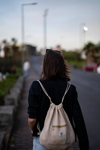 istock Female tourist walking down the road vertical image 1496371683