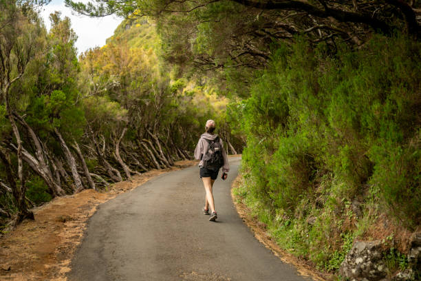 istock Female tourist enjoying tropical climate and walking down a hidden path 1496371791