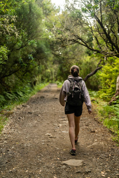 istock Female tourist enjoying tropical climate and walking down a footpath vertical image 1496371803