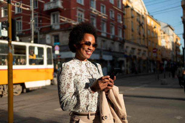istock African tourist, being alone at the unknown city, smiling and using her phone. 1496372648
