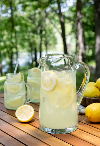 Pitcher of lemonade outdoors on wooden table