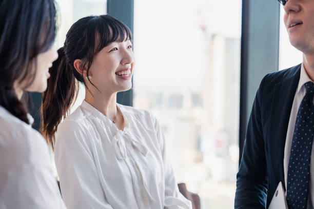 オフィスで親しみやすく話す若いビジネスマン - 職場の人間関係 ストックフォトと画像