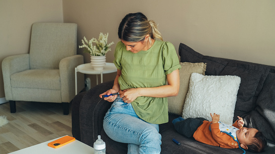 Young mother at home injecting insulin with insulin pen