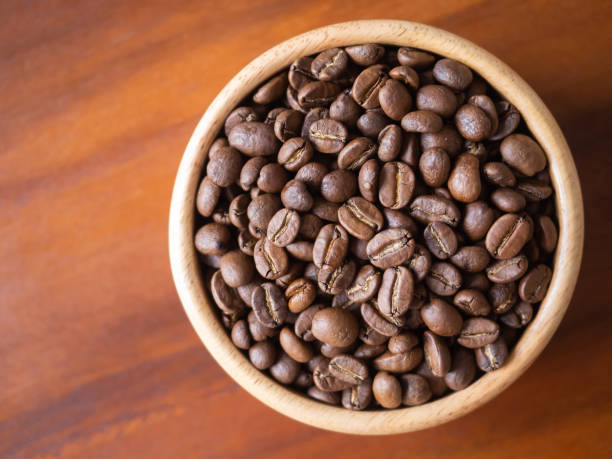 istock brown arabica coffee bean roast level medium taste delicate lively bright seed caffeine espresso drink food cafe beverage Chiang Rai, Thailand coffee on wooden table background top view selected focus 1496375524