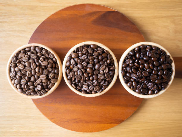 brown arabica coffee bean roast 3 level medium to dark different taste seed caffeine espresso drink food cafe beverage Chiang Rai, Thailand coffee on wooden table background top view selected focus