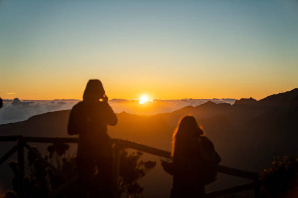 istock Tourists watching a beautiful sunset over tall mountains 1496377258