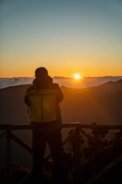 istock Hiker watching a beautiful sunset over tall mountains vertical image 1496377332