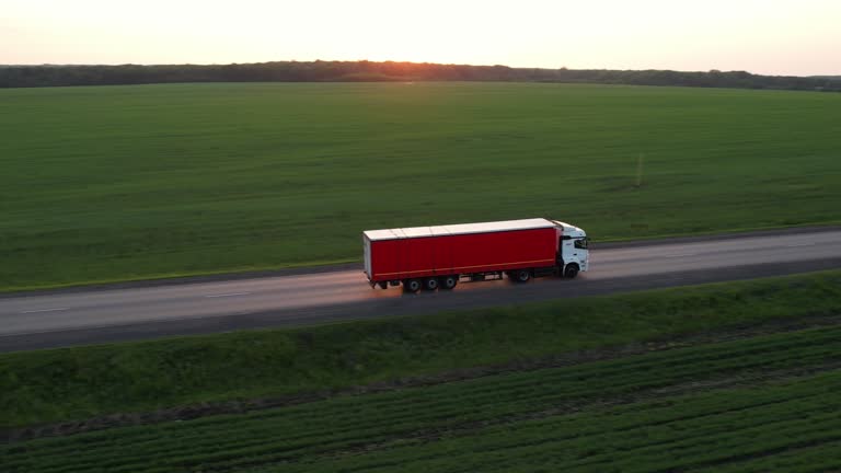 The truck is driving on the highway at sunset, drone view
