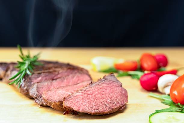istock Freshly cooked steak  with a side of vegetables on a wooden table 1496382949