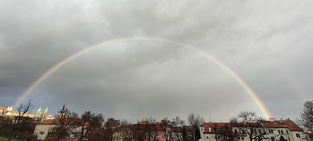 double rainbow photographed in the park below petrin. the cathedral appears right between the two arche