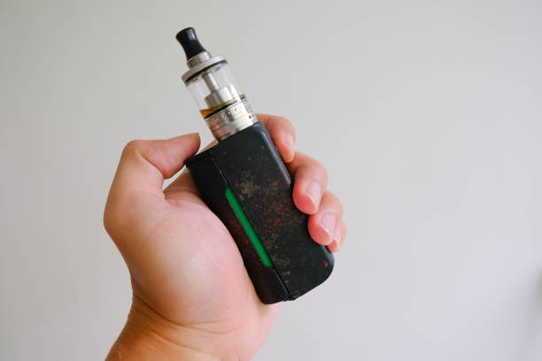 istock hand holding vaporizer, vape or electric cigarette on white background 1496383291