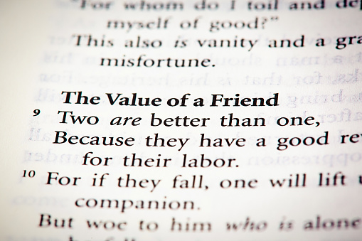 Bible open to Ecclesiastes 4:9, proclaiming the virtue of friendship, because friends can support each other.
