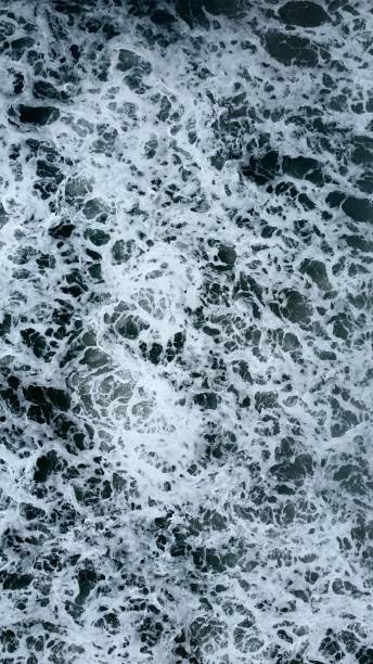 istock water that is swirling and coming to shore from rocks and a wave 1496390167