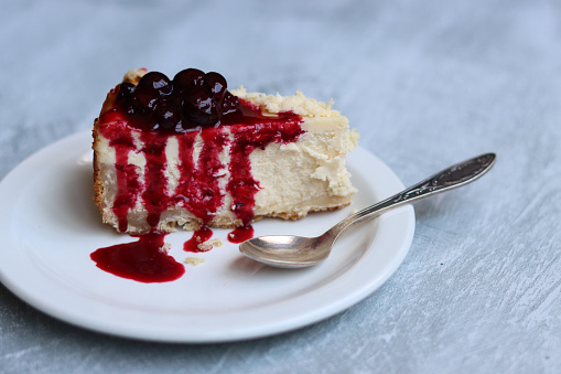 Cheesecake with cherry jam on the table. Close up photo of sweet cake