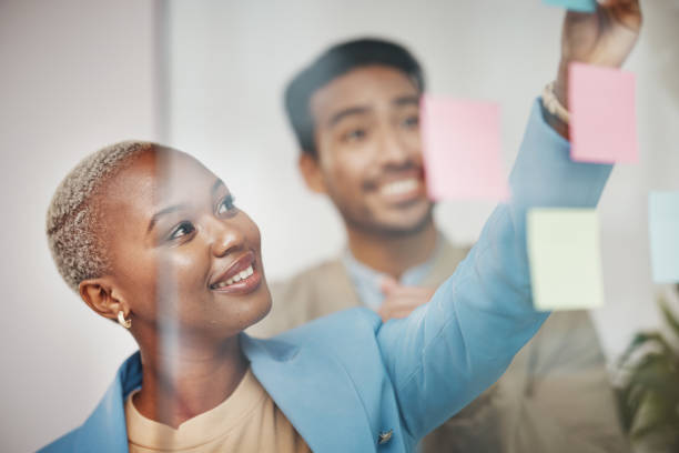 istock Writing, thinking and business people planning schedule, strategy or agenda, sticky note or teamwork. Idea, collaboration and woman leader with goal, visual or problem solving, calendar or solution 1496394074