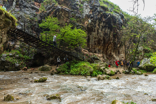 Karachay-Cherkessia, Russia - May 8, 2023: Honey waterfalls, tourists walk the stairway. Honey waterfalls are a group of waterfalls on the Alikonovka and Echki-Bash rivers in Karachay-Cherkessia