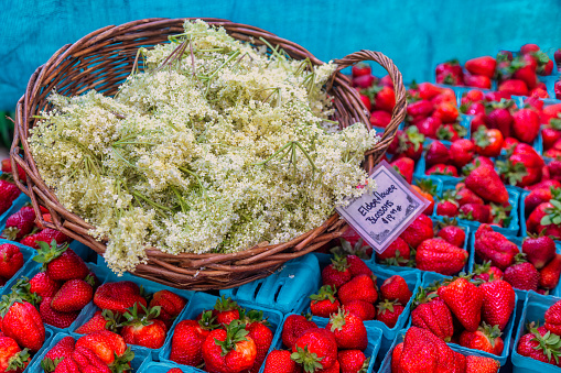 a basket of Elder flowers and strawberries for sale at the farmer's market