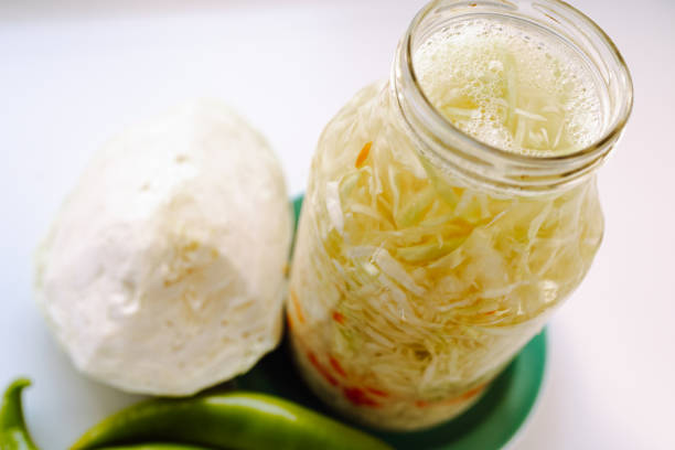 Sauerkraut with carrots in own juice. Cabbage fermentation, vegetable fermentation and storage, long-term storage, healthy nutrition. Shredded cabbage with carrots in glass jar, hot pepper, salad