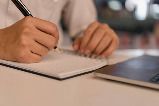 istock man hands with pen writing on notebook in the office.learning, education and work.writes goals, plans, make to do and wish list on desk. 1496399975