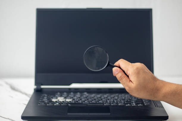 istock magnifying glass in hand looking at laptop to search internet 1496400074