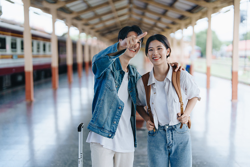 Tourist couples showing their love and happiness in a sweet way while waiting for their journey at the train station
