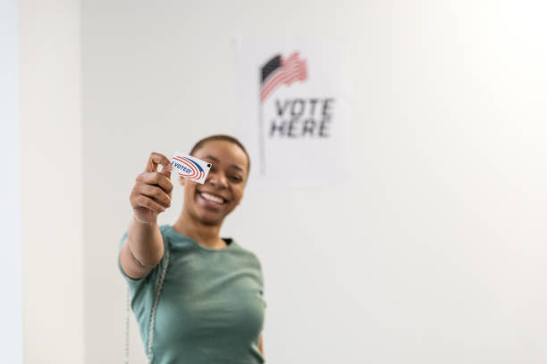 istock Focus on 'I Voted' sticker in young woman's hand 1496405902