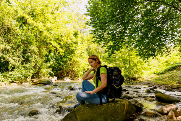 istock A young woman relaxes by sitting by a creek 1496406204