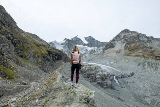 istock Female hiker on mountain ridge looking at glacier 1496407216