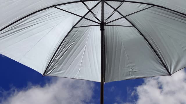 silver umbrella flying in the sky