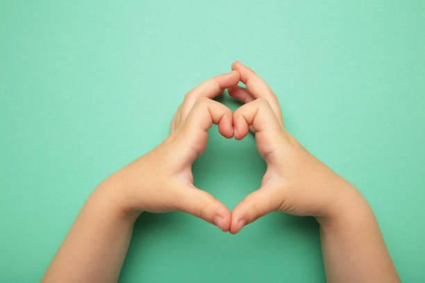 istock Gesturing of the heart from kid hands on mint background. 1496411388