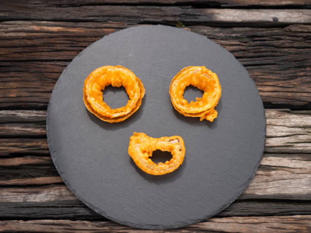 Fried onions decorated like a human face. Top view Plate Design