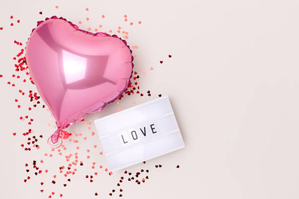 palavra amor. lightbox, confete e balão de folha inflável rosa em forma de coração. - heart shape confetti love single word - fotografias e filmes do acervo