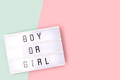 男の子か女の子。ピンクと青の背景に文字を持つライトボックス。