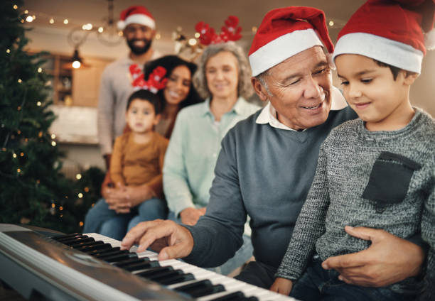 familie, weihnachten und großvater mit enkelkind am klavier zum lernen, lehren und zusammenbinden in ihrem zuhause. musik, instrument und pensionierter pianist treten für kinder und eltern in festlicher feier auf - music child pianist learning stock-fotos und bilder