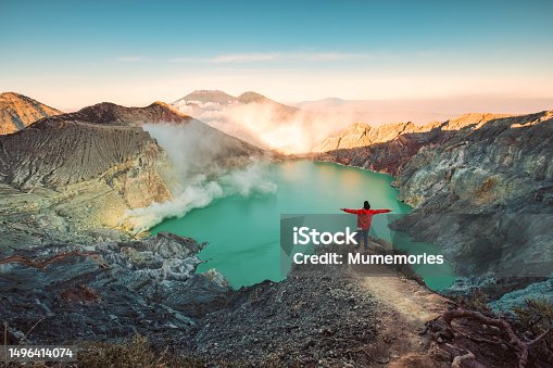 istock Traveler man standing on the crater of Kawah Ijen volcano with sunrise sky in the morning 1496414074