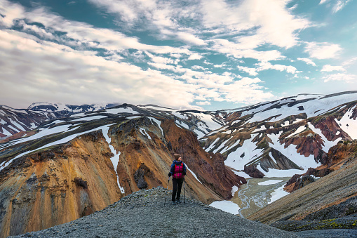 Successful asian hiker woman standing on top of volcanic mountain named Blanhjukur trail in summer at Landmannalaugar, Iceland