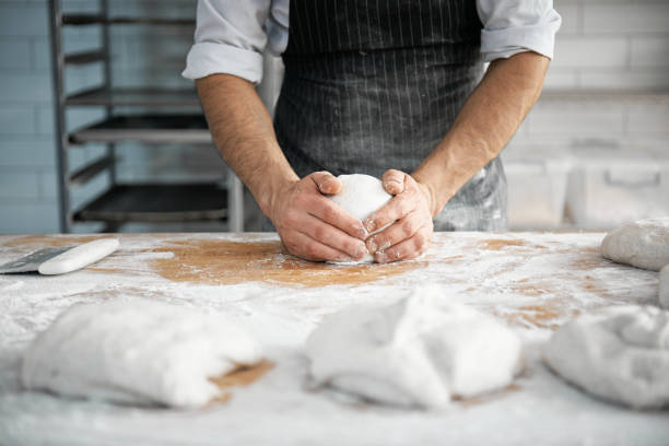 istock Hands Of A Chef Kneading A Dough On A Kitchen Counter To Make Artisan Bread 1496416408