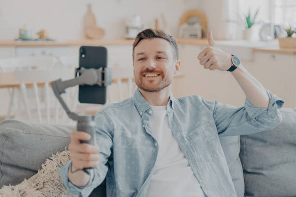 istock Young man in video call expressing his satisfaction by showing thumbs up 1496418048