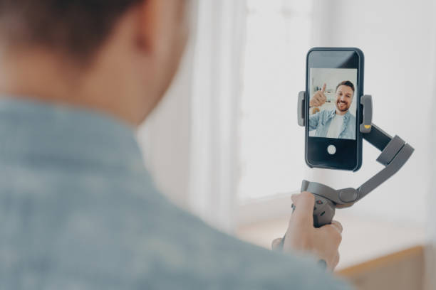 Handsome smiling young brunete man with stubble making selfie on smartphone