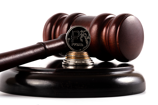 Judge gavel and coin with Russian ruble symbol on white background