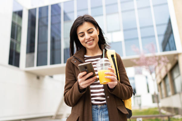 istock Beautiful young woman using smart phone outdoors 1496421663