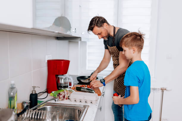 istock Mid Adult Man and Young Son Work Their Culinary Charm 1496423294