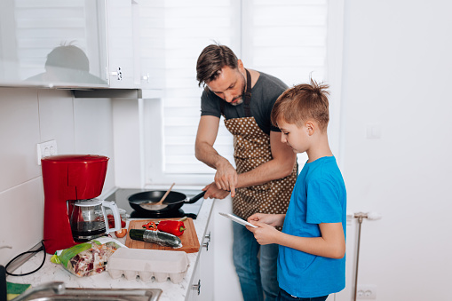 Experience the power of kitchen bonding as a mid adult man and his young son connect on a deeper level through food and fun