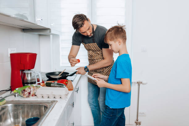istock Mid Adult Man and Young Son Reveal Culinary Magic in the Kitchen 1496423348