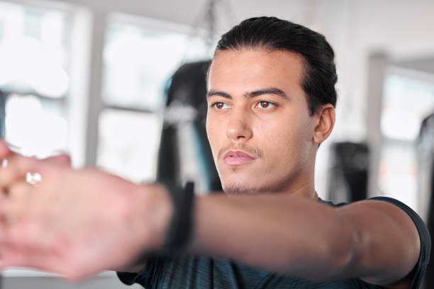 istock Hands, stretching fingers and man in gym ready to start workout, training or exercise. Sports fitness, thinking and serious male athlete warm up, stretch or prepare for exercising for flexibility. 1496424936