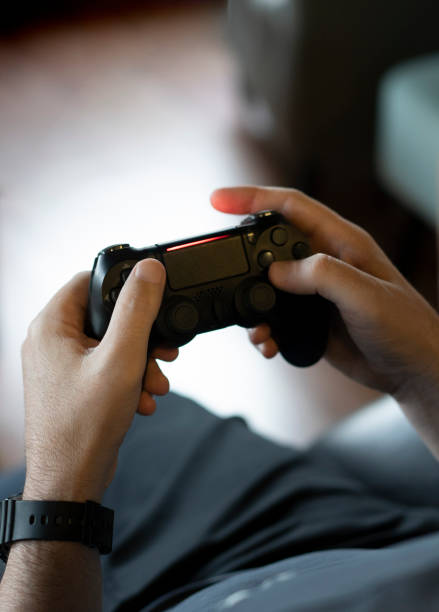 istock High angle view of an adult man's hands holding a joystick while playing a video game on a console 1496426664