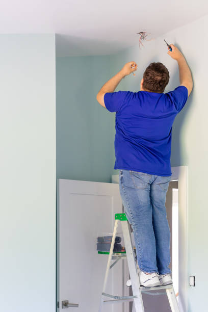 istock A man on a ladder is checking electrical wires on the ceiling 1496430049