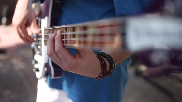 Close-up hands playing  bass guitar