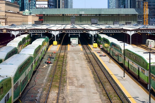 Toronto, Canada - May 13, 2023: Union Station. A rail yard with multiple trains aligned on parallel tracks against the backdrop of surrounding buildings. No people are in the scene.